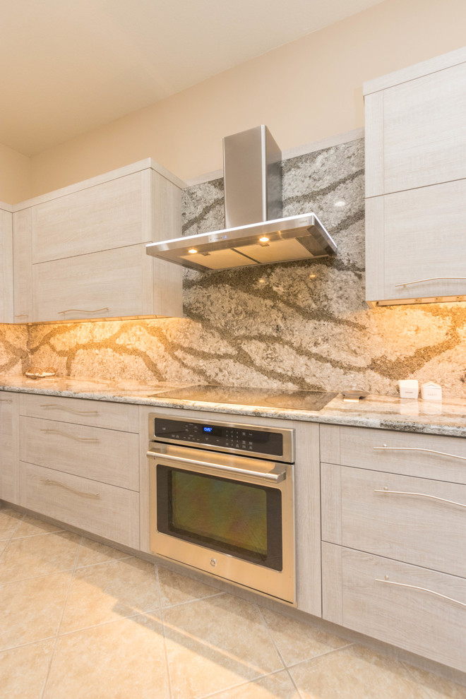 Example of a large trendy u-shaped ceramic tile enclosed kitchen design in Miami with a single-bowl sink, flat-panel cabinets, gray cabinets, quartz countertops, gray backsplash, stone slab backsplash, stainless steel appliances and a peninsula