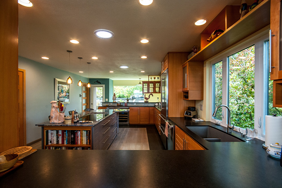Inspiration for a mid-sized contemporary u-shaped medium tone wood floor eat-in kitchen remodel in Portland with an undermount sink, louvered cabinets, medium tone wood cabinets, granite countertops, multicolored backsplash, stone tile backsplash, stainless steel appliances and an island