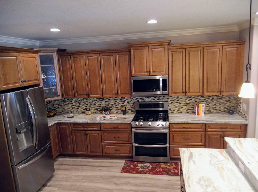 Bild på ett mellanstort vintage flerfärgad flerfärgat kök, med en undermonterad diskho, luckor med upphöjd panel, skåp i mellenmörkt trä, granitbänkskiva, flerfärgad stänkskydd, stänkskydd i travertin, rostfria vitvaror, klinkergolv i porslin, en halv köksö och grått golv