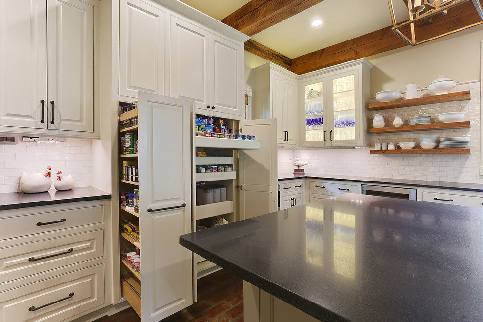 Example of a large country u-shaped brick floor kitchen pantry design in New Orleans with an undermount sink, beaded inset cabinets, white cabinets, granite countertops, white backsplash, stainless steel appliances, an island and subway tile backsplash