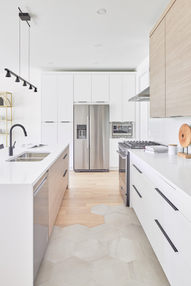 Foto di una cucina minimal con lavello sottopiano, ante lisce, ante bianche, elettrodomestici in acciaio inossidabile, pavimento grigio, top bianco e parquet e piastrelle