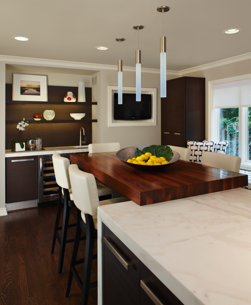 Immagine di una cucina design di medie dimensioni con ante lisce, ante in legno bruno, parquet scuro, lavello sottopiano, top in marmo e elettrodomestici in acciaio inossidabile