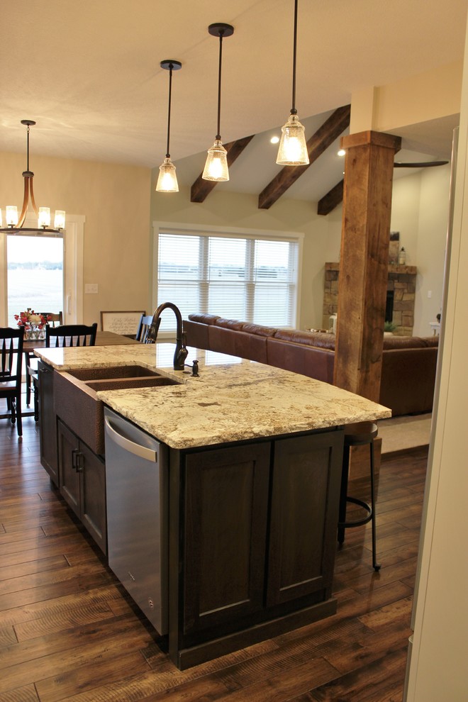 Mid-sized mountain style l-shaped medium tone wood floor and brown floor open concept kitchen photo in Other with a farmhouse sink, flat-panel cabinets, white cabinets, granite countertops, beige backsplash, travertine backsplash, stainless steel appliances, an island and beige countertops