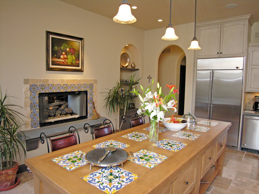Foto på ett medelhavsstil kök, med skåp i ljust trä, beige stänkskydd, stänkskydd i stenkakel och rostfria vitvaror