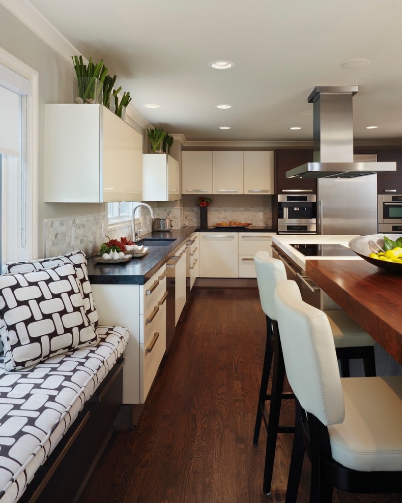 Foto de cocina actual con armarios con paneles lisos, electrodomésticos de acero inoxidable, encimera de madera y barras de cocina
