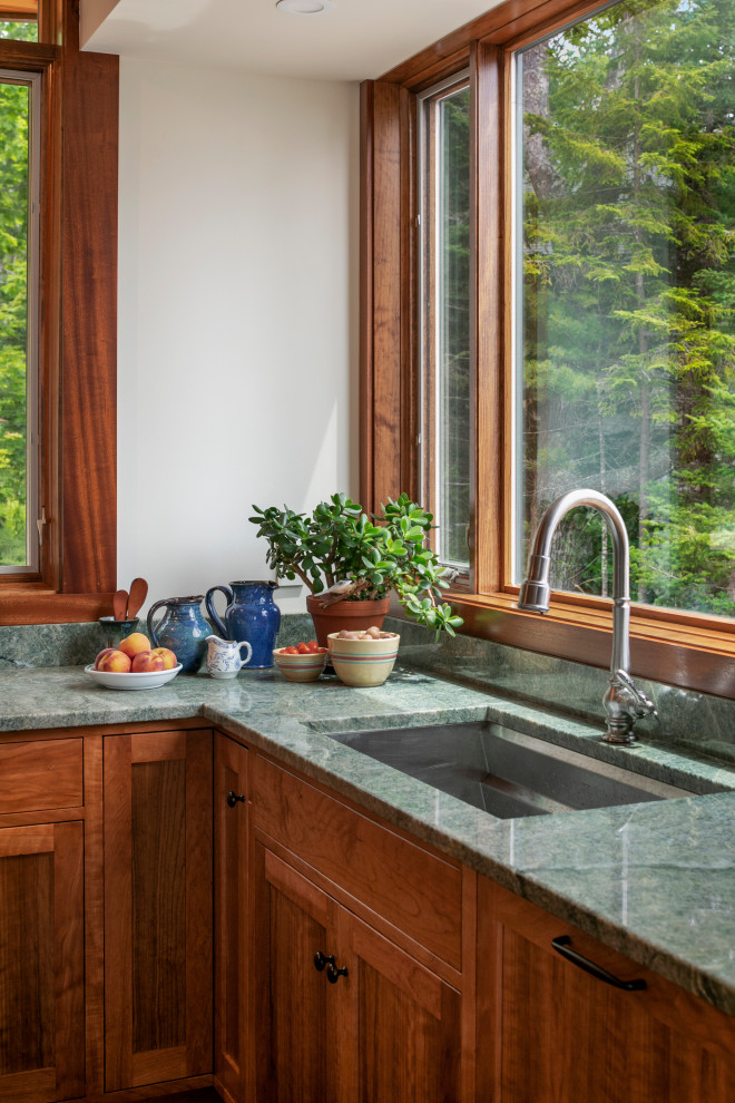 Photo of a large contemporary l-shaped open plan kitchen in Portland Maine with a submerged sink, recessed-panel cabinets, medium wood cabinets, black appliances, medium hardwood flooring, an island and green worktops.