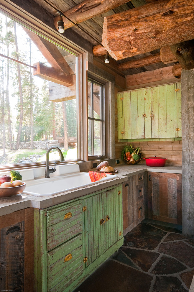Mountain style kitchen photo in Other with concrete countertops, a drop-in sink and distressed cabinets