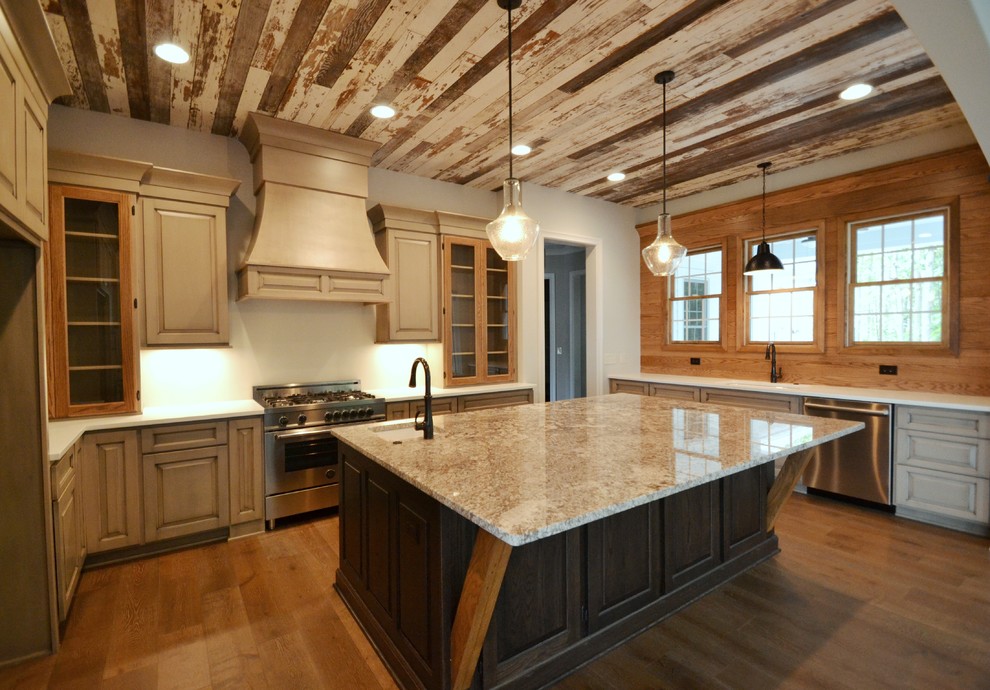 Ejemplo de cocina comedor rústica grande con armarios tipo vitrina, encimera de granito, suelo de madera en tonos medios y una isla