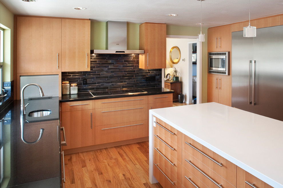 Moderne Küche in U-Form mit Waschbecken, flächenbündigen Schrankfronten, hellen Holzschränken, Küchenrückwand in Schwarz und Küchengeräten aus Edelstahl in Boise