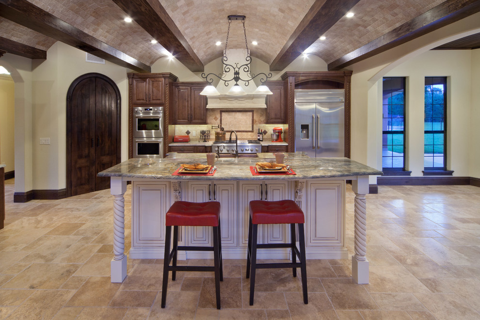 Foto på ett stort medelhavsstil kök, med en rustik diskho, luckor med upphöjd panel, skåp i mellenmörkt trä, granitbänkskiva, flerfärgad stänkskydd, stänkskydd i stenkakel, rostfria vitvaror, travertin golv och en köksö
