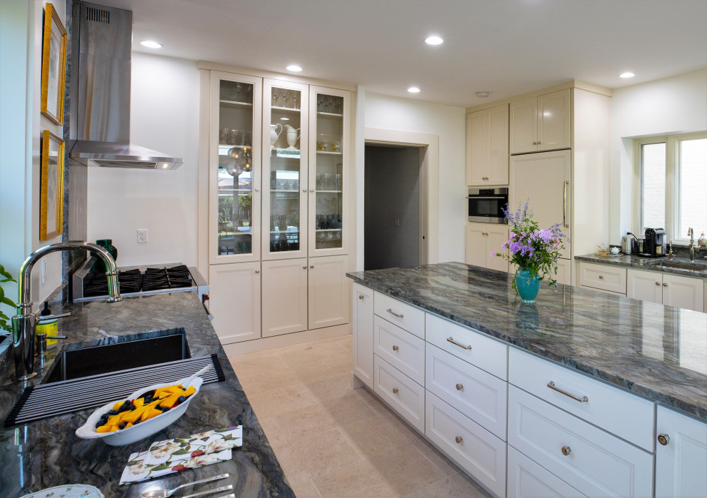 Design ideas for a traditional kitchen in Philadelphia with white cabinets, granite worktops, integrated appliances, limestone flooring, an island, beige floors, green worktops and recessed-panel cabinets.