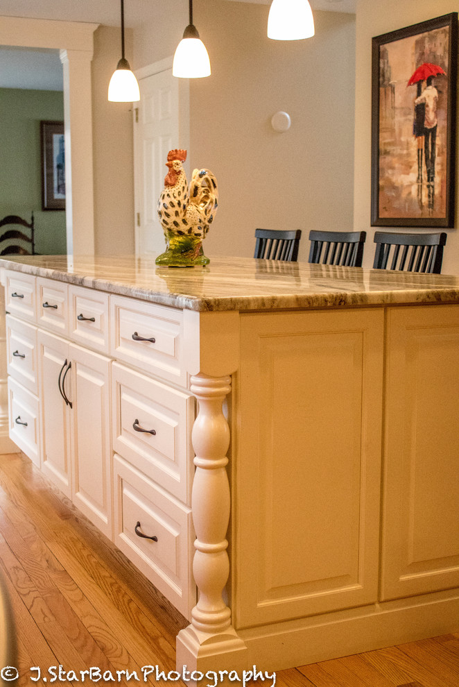 Klassisk inredning av ett mellanstort kök, med en dubbel diskho, luckor med upphöjd panel, skåp i mellenmörkt trä, marmorbänkskiva, vitt stänkskydd, stänkskydd i keramik, rostfria vitvaror, ljust trägolv och en köksö