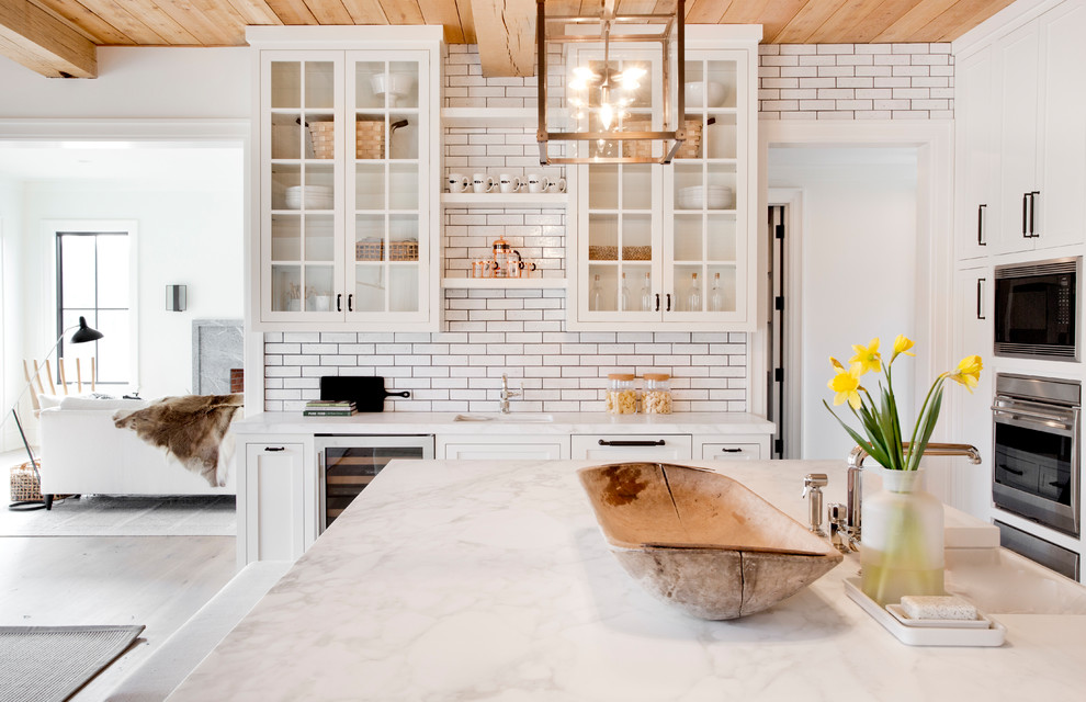 Kitchen - huge scandinavian l-shaped light wood floor and beige floor kitchen idea in New York with shaker cabinets, white cabinets, quartz countertops, white backsplash, subway tile backsplash, stainless steel appliances, an island and a farmhouse sink