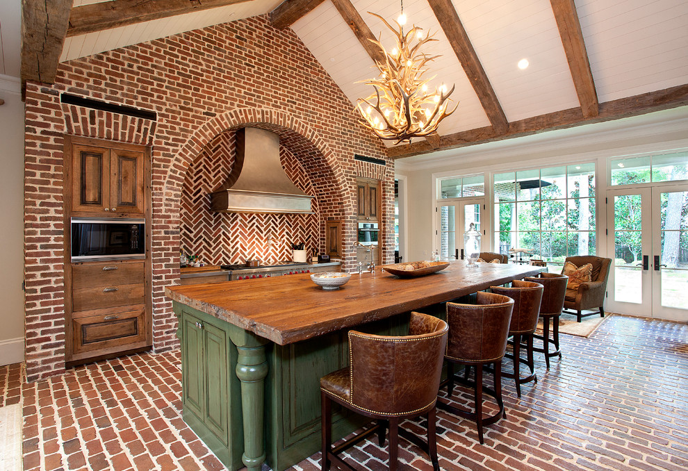 Inspiration for a rustic galley brick floor kitchen remodel in Houston with raised-panel cabinets, medium tone wood cabinets, wood countertops, red backsplash and an island