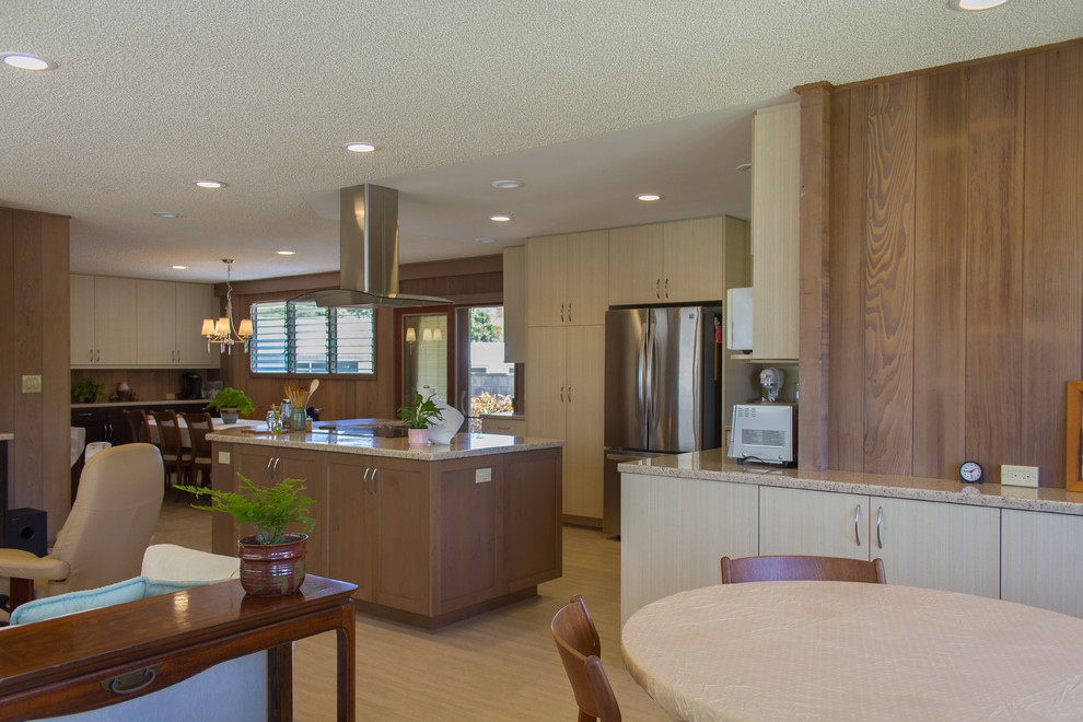 Offene Moderne Küche mit flächenbündigen Schrankfronten, hellen Holzschränken, Mineralwerkstoff-Arbeitsplatte, Küchengeräten aus Edelstahl, Vinylboden und Kücheninsel in Hawaii
