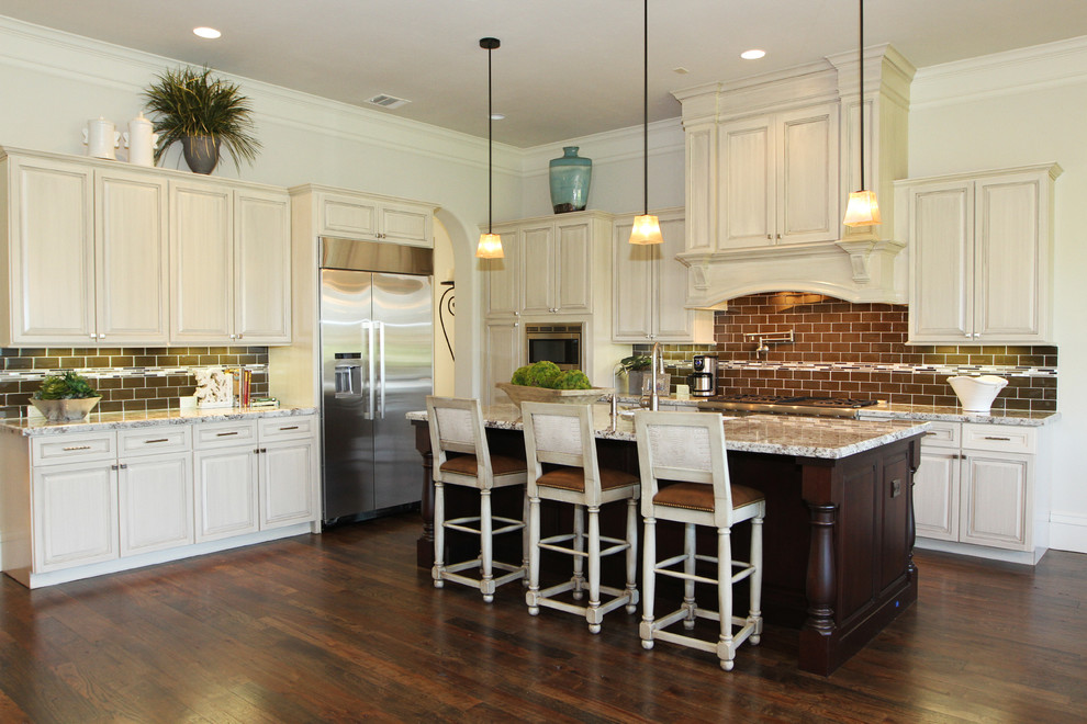 Mid-sized elegant l-shaped dark wood floor open concept kitchen photo in Houston with white cabinets, brown backsplash and an island