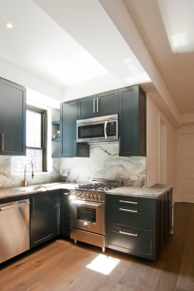 Exempel på ett mellanstort modernt grå grått kök, med en undermonterad diskho, luckor med infälld panel, blå skåp, bänkskiva i kalksten, grått stänkskydd, stänkskydd i sten, rostfria vitvaror, ljust trägolv och brunt golv