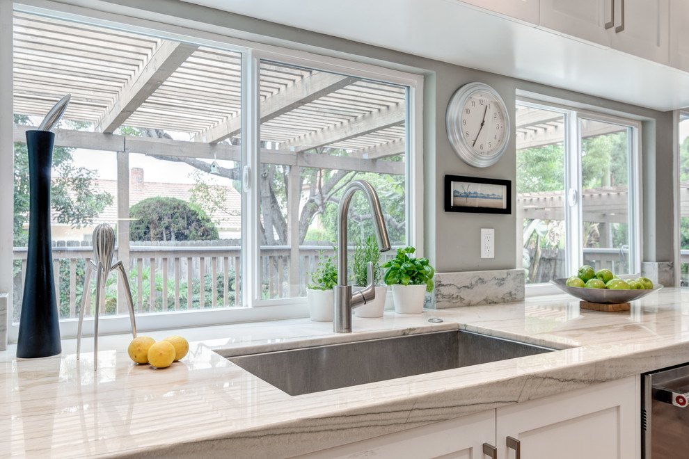 Example of a mid-sized transitional galley medium tone wood floor eat-in kitchen design in San Diego with an undermount sink, shaker cabinets, white cabinets, quartzite countertops, blue backsplash, porcelain backsplash, stainless steel appliances and no island