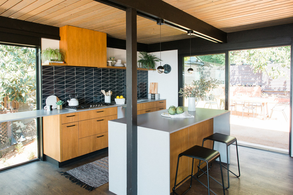 Immagine di un cucina con isola centrale moderno con ante lisce, ante in legno scuro, paraspruzzi nero, parquet scuro, pavimento marrone e top bianco