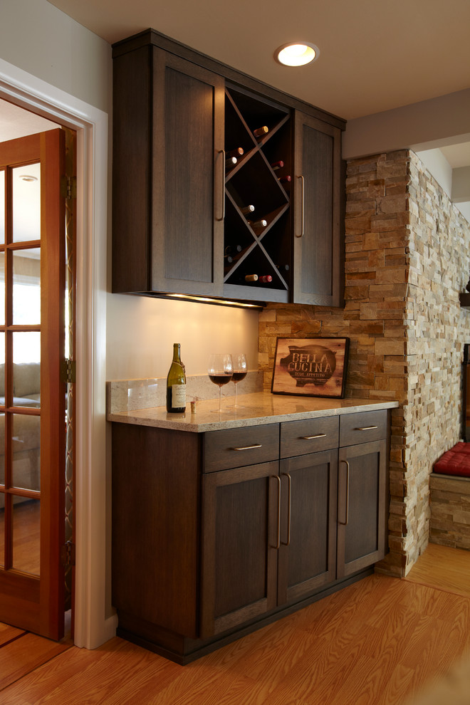 Bild på ett mellanstort funkis kök, med en undermonterad diskho, skåp i shakerstil, skåp i mörkt trä, granitbänkskiva, stänkskydd i sten, rostfria vitvaror, ljust trägolv och en köksö