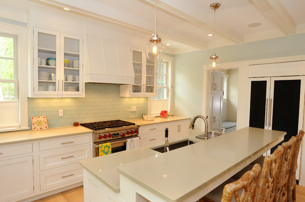 На фото: параллельная кухня в морском стиле с врезной мойкой, фасадами в стиле шейкер, белыми фасадами, зеленым фартуком и фартуком из стеклянной плитки с
