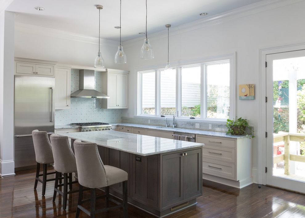 Example of a mid-sized transitional l-shaped dark wood floor eat-in kitchen design in New Orleans with white cabinets, multicolored backsplash, mosaic tile backsplash, stainless steel appliances, an island, an undermount sink, shaker cabinets and marble countertops