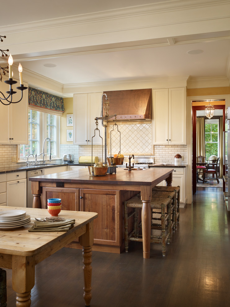 На фото: кухня в классическом стиле с техникой из нержавеющей стали, деревянной столешницей и двухцветным гарнитуром с