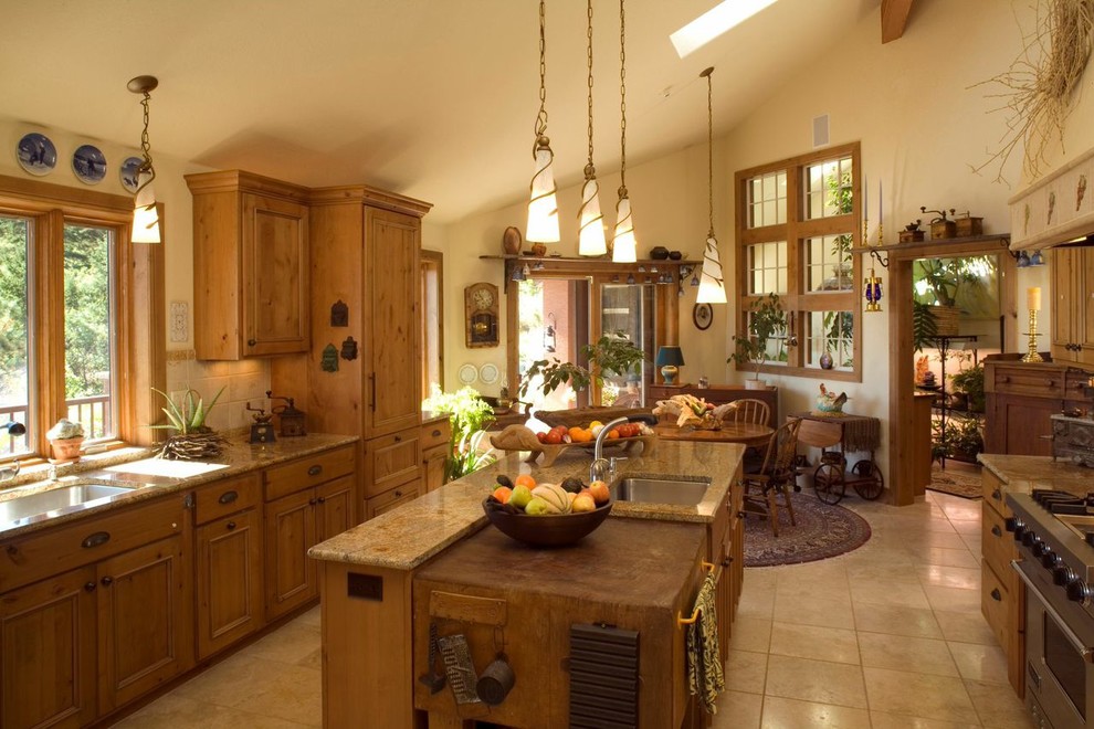 Enclosed kitchen - large southwestern u-shaped travertine floor and beige floor enclosed kitchen idea in Albuquerque with an undermount sink, beaded inset cabinets, medium tone wood cabinets, granite countertops, beige backsplash, ceramic backsplash, stainless steel appliances and an island