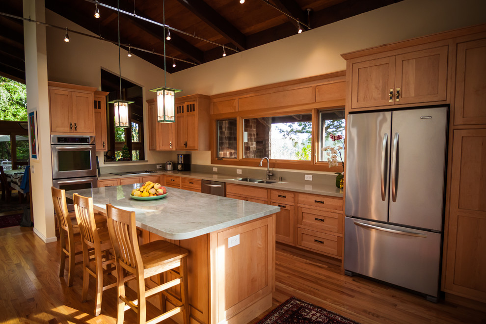 Inspiration for a mid-sized craftsman l-shaped medium tone wood floor enclosed kitchen remodel in San Francisco with a double-bowl sink, shaker cabinets, light wood cabinets, quartzite countertops, green backsplash, stone slab backsplash, stainless steel appliances and an island