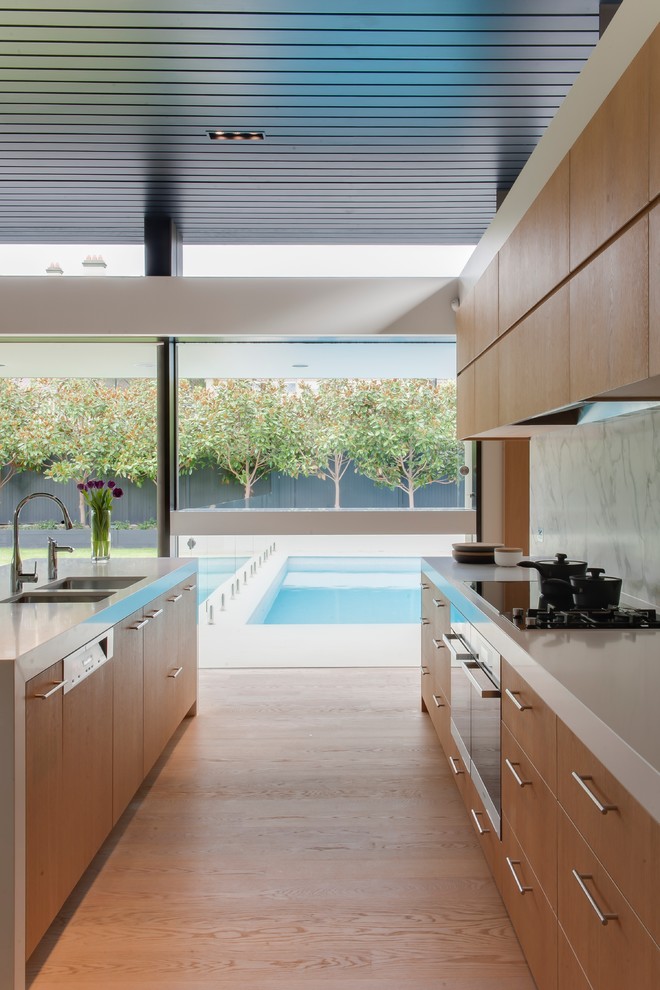 Offene Moderne Küche mit Doppelwaschbecken, flächenbündigen Schrankfronten, hellbraunen Holzschränken und braunem Holzboden in Sydney
