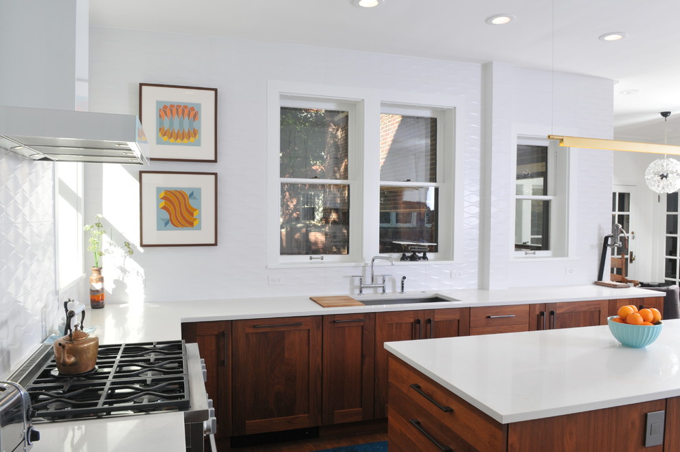 Bild på ett stort eklektiskt vit vitt kök, med en undermonterad diskho, skåp i mellenmörkt trä, bänkskiva i kvarts, vitt stänkskydd, stänkskydd i keramik, vita vitvaror, mellanmörkt trägolv, en köksö och brunt golv