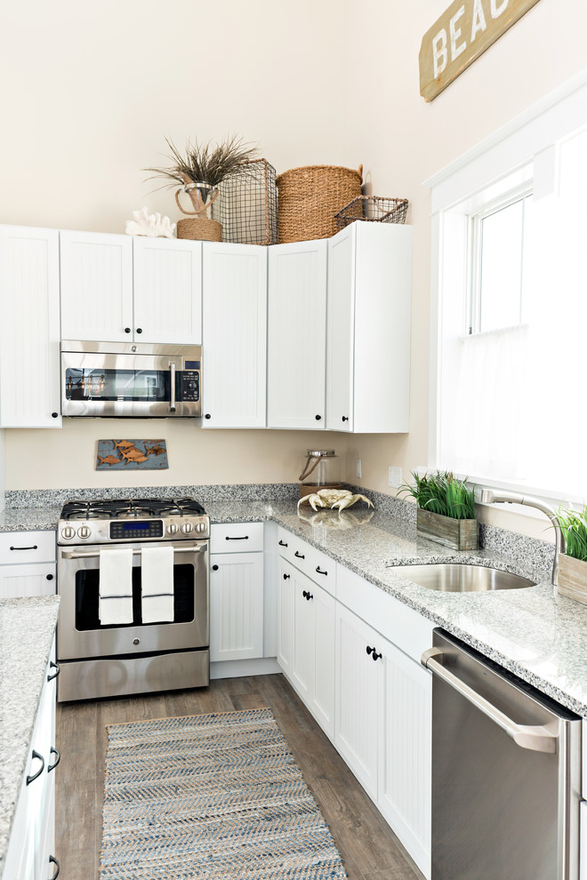 Example of a large beach style l-shaped dark wood floor eat-in kitchen design in Boston with an undermount sink, recessed-panel cabinets, white cabinets, granite countertops, stainless steel appliances and an island