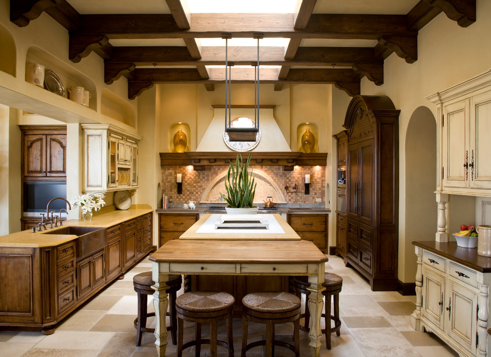 Exempel på ett medelhavsstil kök och matrum, med en rustik diskho, skåp i mörkt trä, beige stänkskydd, en köksö och beiget golv