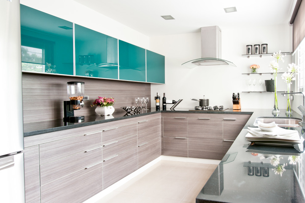 На фото: п-образная кухня в современном стиле с двойной мойкой, плоскими фасадами, синими фасадами и коричневым фартуком