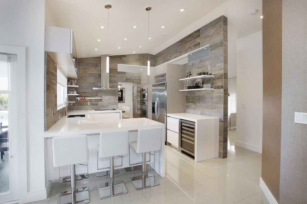 Inspiration for a mid-sized contemporary u-shaped linoleum floor enclosed kitchen remodel in Miami with an undermount sink, flat-panel cabinets, white cabinets, solid surface countertops, stainless steel appliances and a peninsula