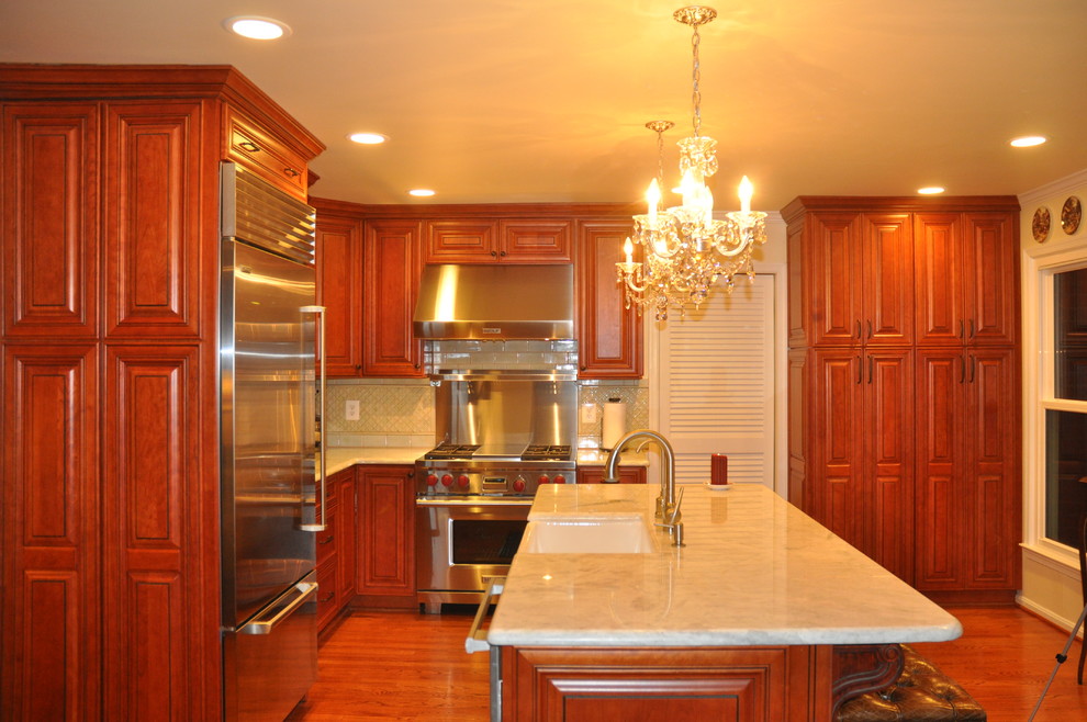 Exempel på ett avskilt, mellanstort klassiskt l-kök, med en rustik diskho, luckor med upphöjd panel, skåp i mörkt trä, granitbänkskiva, beige stänkskydd, stänkskydd i keramik, rostfria vitvaror, mörkt trägolv, en köksö och brunt golv