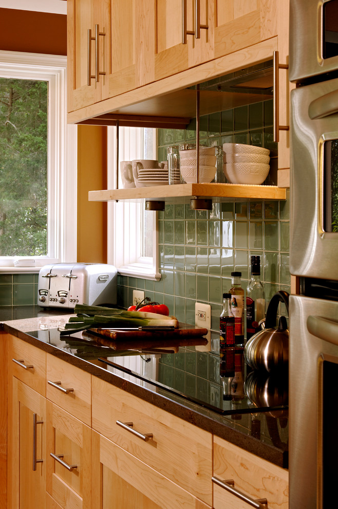 Bild på ett mellanstort vintage kök, med en undermonterad diskho, skåp i shakerstil, skåp i ljust trä, granitbänkskiva, grönt stänkskydd, stänkskydd i glaskakel, rostfria vitvaror, ljust trägolv, en köksö och beiget golv