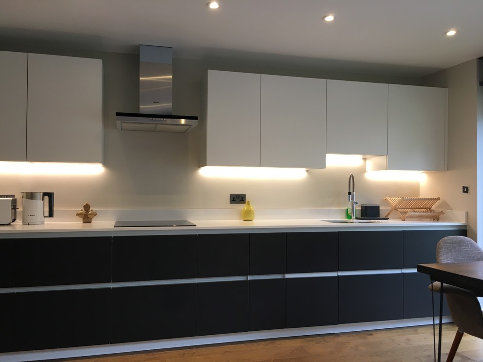 Design ideas for a medium sized contemporary l-shaped open plan kitchen in London with a double-bowl sink, flat-panel cabinets, quartz worktops, medium hardwood flooring and no island.