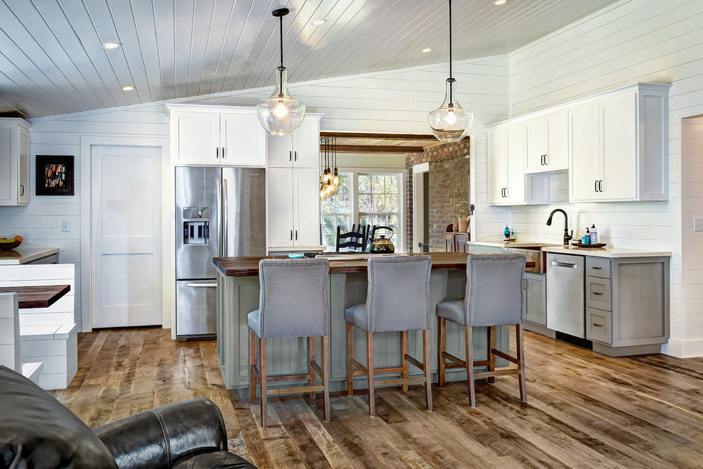 Open concept kitchen - mid-sized rustic u-shaped medium tone wood floor and brown floor open concept kitchen idea in Charleston with a farmhouse sink, shaker cabinets, gray cabinets, wood countertops, white backsplash, wood backsplash, stainless steel appliances and an island