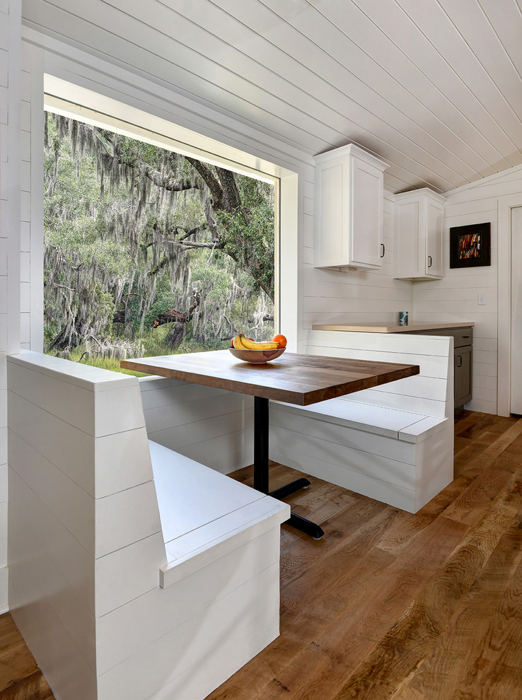 Inspiration for a mid-sized rustic u-shaped medium tone wood floor open concept kitchen remodel in Charleston with a farmhouse sink, shaker cabinets, gray cabinets, wood countertops, white backsplash, wood backsplash, stainless steel appliances and an island