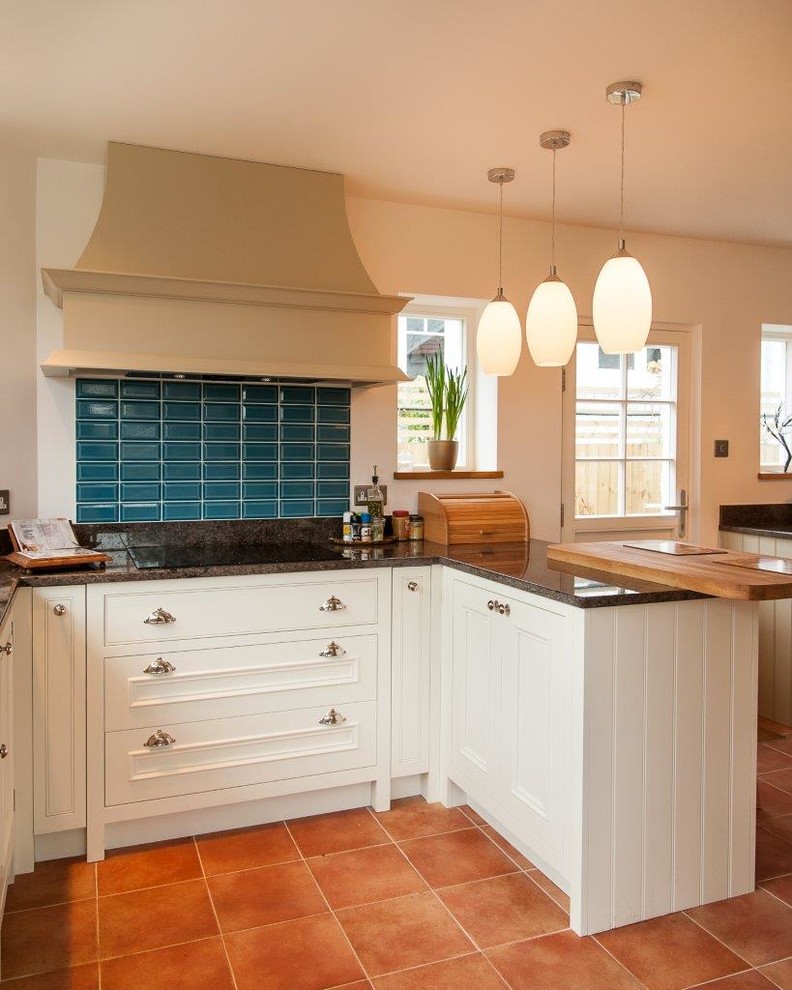 Example of a mid-sized trendy u-shaped slate floor and orange floor eat-in kitchen design in Hertfordshire with a drop-in sink, shaker cabinets, beige cabinets, granite countertops, black backsplash, ceramic backsplash, stainless steel appliances and a peninsula