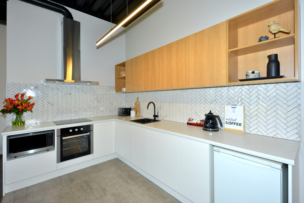 Idéer för mellanstora kök och matrum, med vita skåp, vitt stänkskydd, stänkskydd i mosaik, rostfria vitvaror, klinkergolv i porslin och grått golv