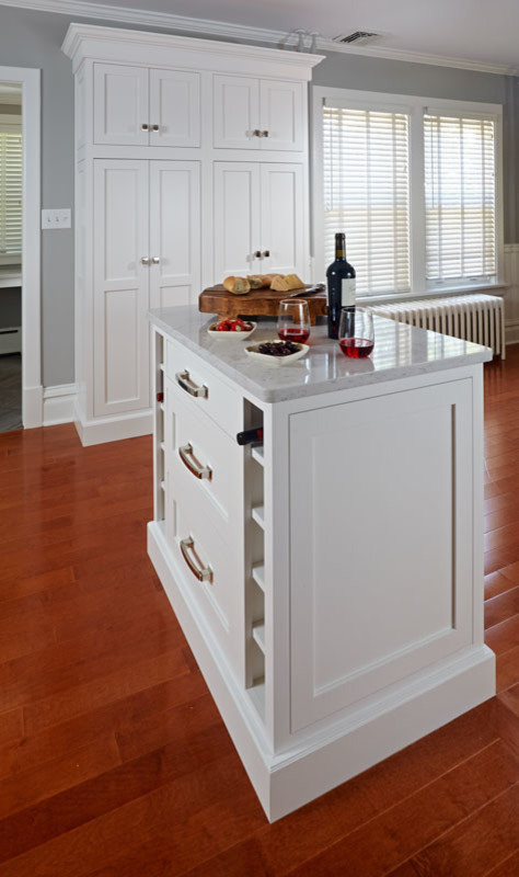 Example of a small arts and crafts u-shaped medium tone wood floor eat-in kitchen design in Other with an undermount sink, shaker cabinets, white cabinets, quartz countertops, white backsplash, porcelain backsplash, stainless steel appliances and an island