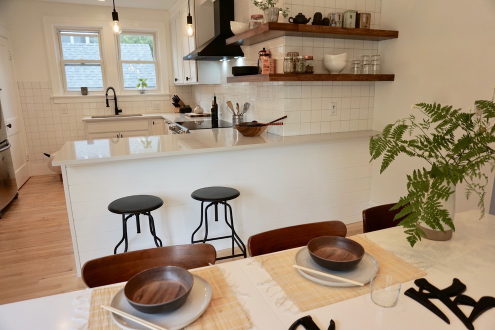 Idéer för ett litet minimalistiskt vit kök, med en undermonterad diskho, skåp i shakerstil, vita skåp, bänkskiva i kvarts, vitt stänkskydd, stänkskydd i keramik, rostfria vitvaror, ljust trägolv, en halv köksö och beiget golv