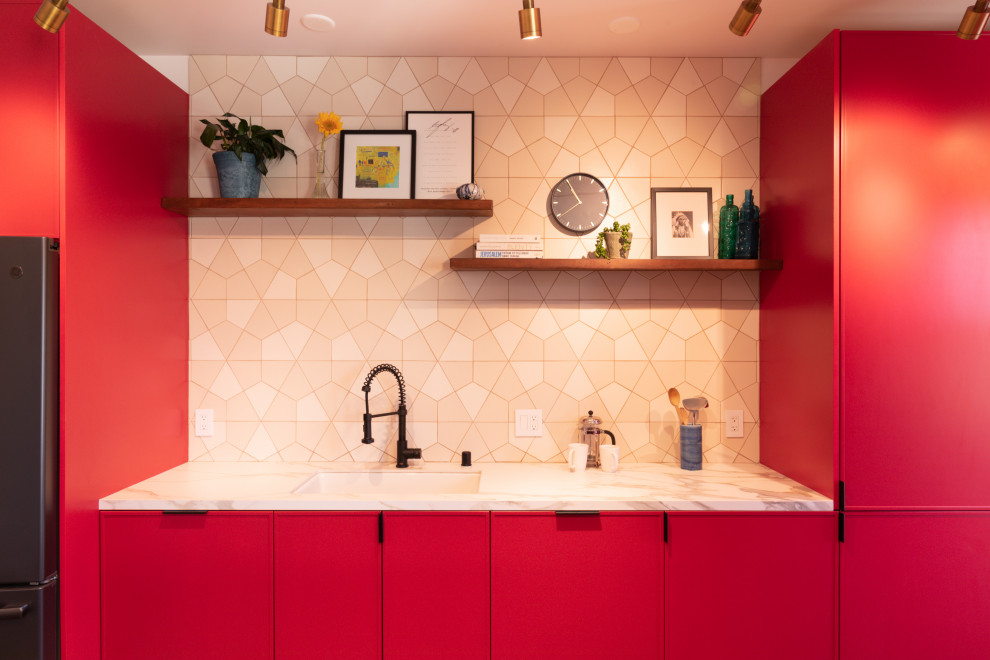 Exemple d'une grande cuisine américaine linéaire moderne avec des portes de placard rouges, plan de travail en marbre, une crédence blanche, une crédence en céramique, un sol en bois brun, îlot, un sol marron et un plan de travail blanc.