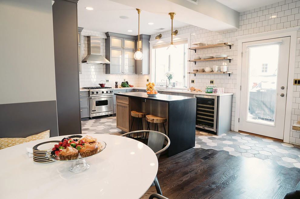 Example of a mid-sized minimalist l-shaped cement tile floor and black floor open concept kitchen design in Los Angeles with a single-bowl sink, glass-front cabinets, gray cabinets, marble countertops, white backsplash, ceramic backsplash, stainless steel appliances and an island