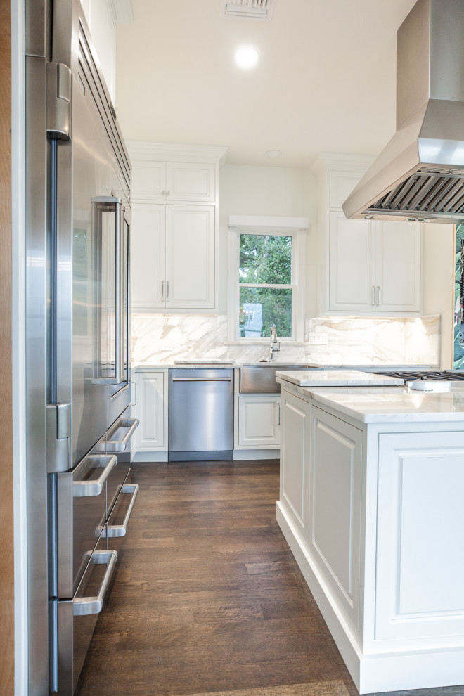 Design ideas for a large traditional kitchen/diner in Tampa with a double-bowl sink, white cabinets, granite worktops, stainless steel appliances, dark hardwood flooring, an island, brown floors and white worktops.