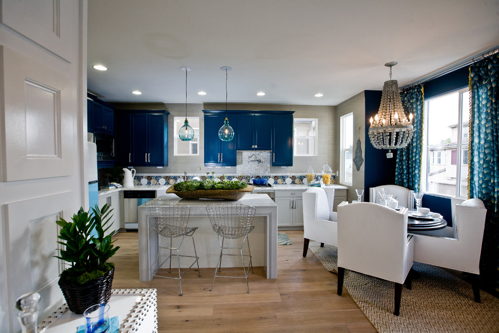 Inredning av ett modernt kök, med blå skåp och flerfärgad stänkskydd
