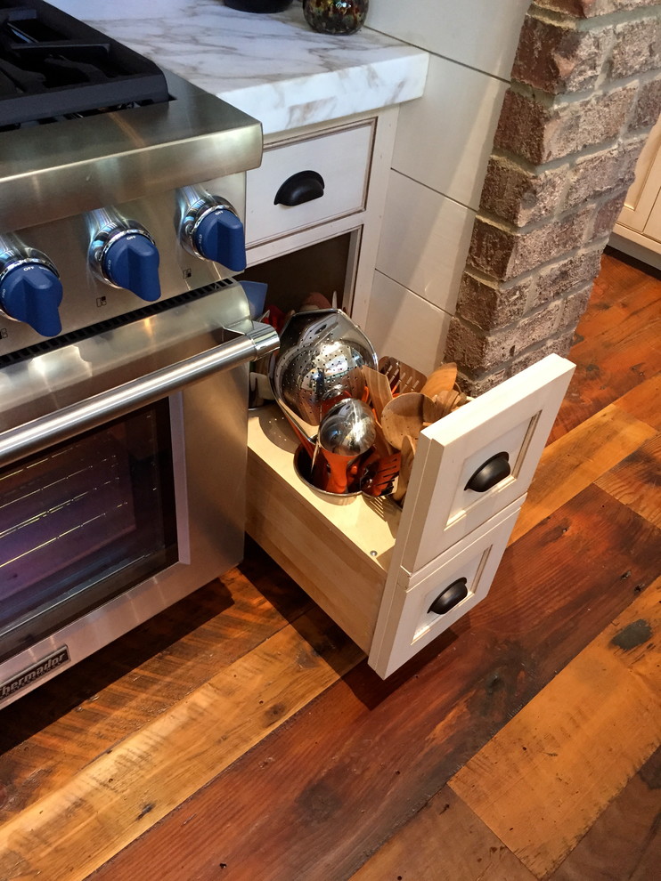 アトランタにある中くらいなカントリー風のおしゃれなキッチン (シェーカースタイル扉のキャビネット、濃色木目調キャビネット、シルバーの調理設備、無垢フローリング) の写真