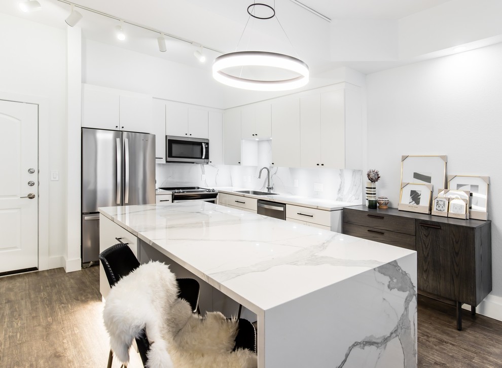 Exempel på ett litet modernt vit vitt kök, med en undermonterad diskho, släta luckor, vita skåp, bänkskiva i glas, vitt stänkskydd, stänkskydd i porslinskakel, rostfria vitvaror, vinylgolv, en köksö och brunt golv